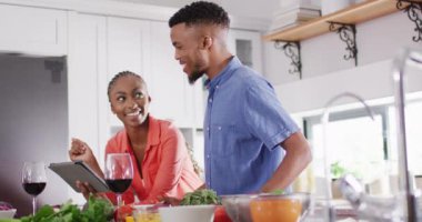 Happy african american couple preparing meal in kitchen. Lifestyle, relationship, spending free time together concept.