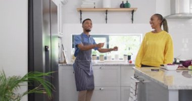 Happy african american couple dancing in kitchen. Lifestyle, relationship, fun, spending free time together concept.