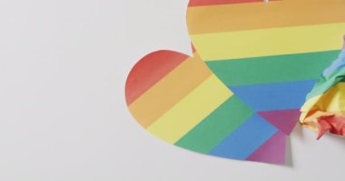 Video of rainbow hearts over white surface with copy space. Gender, lgbt, queer, gay pride and equality concept.