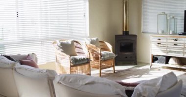 House interior of sunny living room with two chairs, tv and fireplace. House interior and furniture concept.