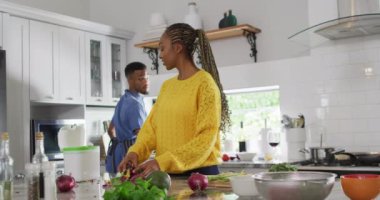 Happy african american couple preparing meal in kitchen. Lifestyle, relationship, spending free time together concept.