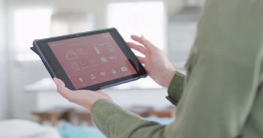 Beyaz kadın evde akıllı ev arayüzü olan tablet kullanıyor. Ev kavramında kaliteli zaman geçirmek.