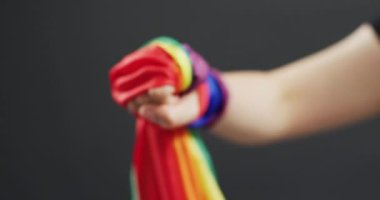 Video of hand of caucasian man with rainbow ribbon. Gender, lgbt, queer, gay pride and equality concept.