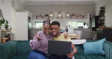 Happy african american couple talking to camera during video call on tablet. Lifestyle, relationship, spending free time together concept.