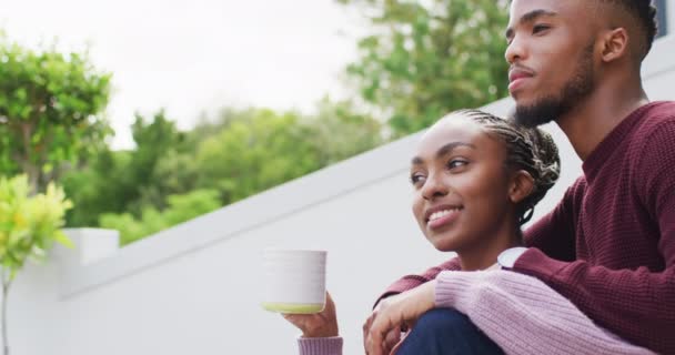 Szczęśliwa Afrykańska Para Obejmująca Relaksująca Się Przy Kawie Zewnątrz Domu — Wideo stockowe