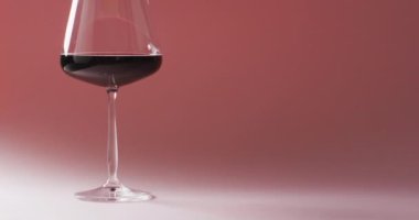 Glass of red wine standing over marsala background with copy space. Wine, alcohol, beverage and wine tasting concept.