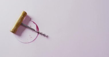 Corkscrew and red wine stain on white surface with copy space. Wine, alcohol, beverage and wine tasting concept.