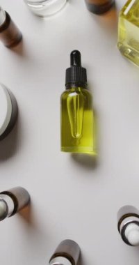 Beyaz arka planda farklı güzellik ürünlerinin dikey videosu. Güzellik ürünleri, kozmetik ürünleri ve cilt bakımı.