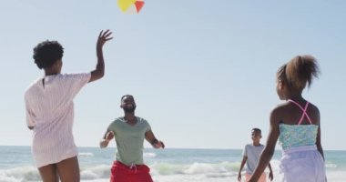 Mutlu Afro-Amerikan ailesi top oynuyor, kumsalda eğleniyor. Tatiller, tatiller, rahatlama ve aile içinde kaliteli zaman geçirme kavramı..