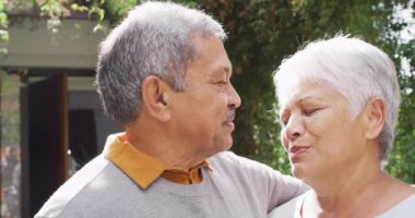 Happy senior diverse couple embracing in garden. Spending quality time at home, retirement and lifestyle concept.