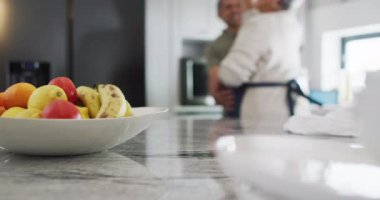 Happy senior biracial couple dancing in kitchen. Spending quality time at home, retirement and lifestyle concept.