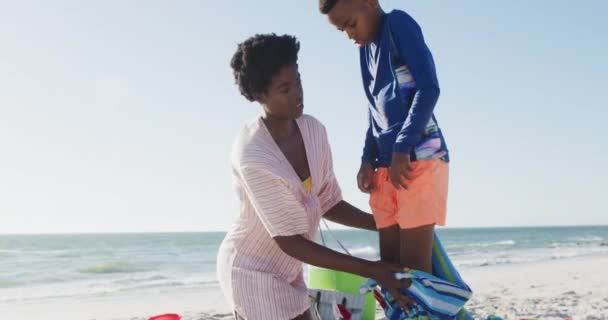 Video Feliz Madre Afroamericana Cubriendo Hijo Playa Vacaciones Vacaciones Relajarse — Vídeos de Stock