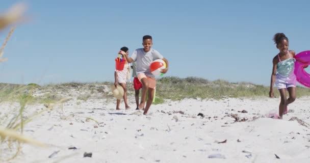 Szczęśliwa Afrykańska Rodzina Wyposażeniem Plażowym Spacerująca Plaży Słoneczny Dzień Wakacje — Wideo stockowe
