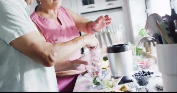 快乐的老夫妇在厨房里准备健康的饮料 在家里度过高质量的时光 退休和生活方式概念 — 图库视频影像