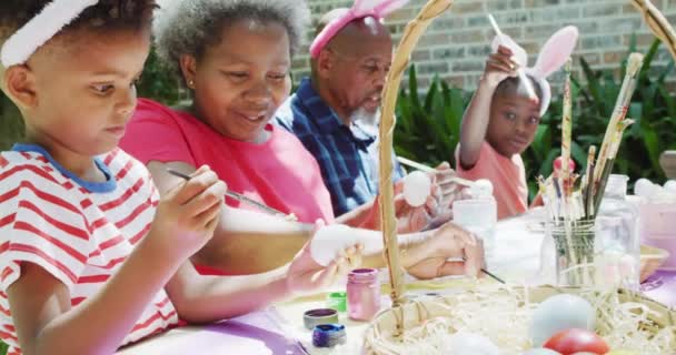 快乐的非洲裔美国祖父母和孙子孙女在花园里装饰着复活节彩蛋 动作缓慢 复活节 聚会和传统概念 — 图库视频影像