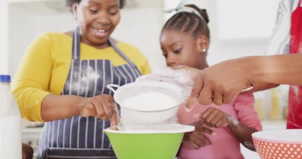 笑着的非洲裔美国祖父母和快乐的孙女在厨房里慢吞吞地烘烤着 烹调和团聚概念 — 图库视频影像