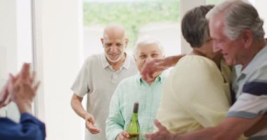 Happy couple greeting group of diverse senior male and female friends at front door, slow motion. Friendship, relaxation and senior lifestyle.