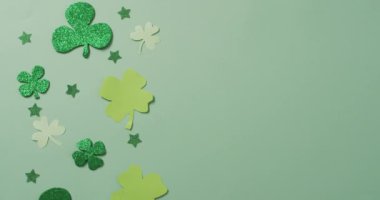 Shamrocks and stars with copy space on green background. Irish tradition and st patrick's day celebration concept digitally generated video.