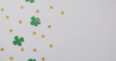 Shamrocks and stars with copy space on white background. Irish tradition and st patrick's day celebration concept digitally generated video.