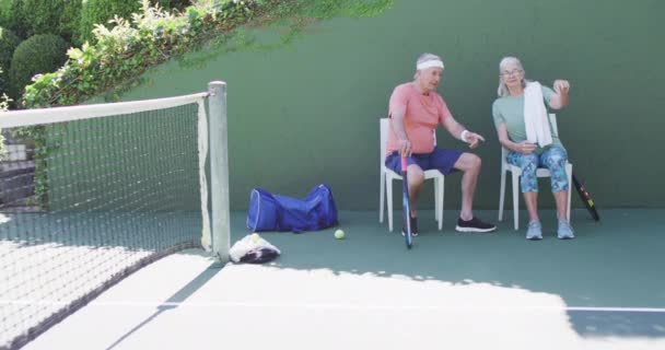 Gelukkig Senior Kaukasisch Echtpaar Neemt Een Pauze Zitten Praten Tennisbaan — Stockvideo