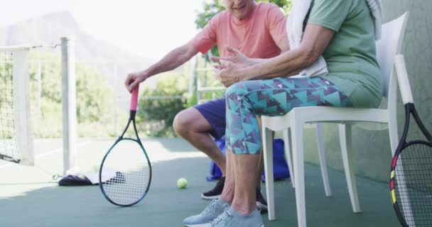 Happy Senior Caucasian Couple Taking Break Talking Sunny Outdoor Tennis — стоковое видео