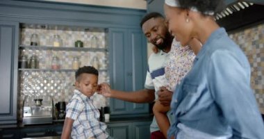 Afro-Amerikan ailesinin mutfakta yavaş çekimde konuşmaları ve yemek pişirmeleri kutlu olsun. Ev kavramında kaliteli zaman geçirmek.