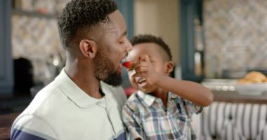 Afro-Amerikan baba ve oğlunun kahvaltısı kutlu olsun, ağır çekimde. Ev kavramında kaliteli zaman geçirmek.