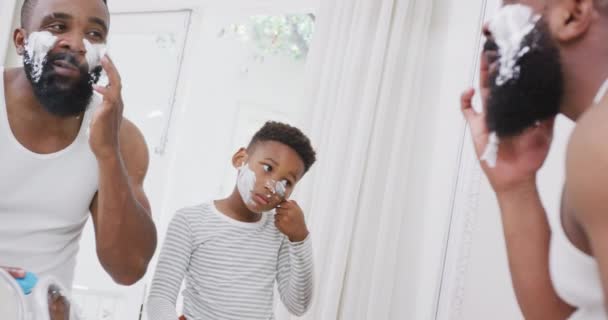 快乐的非洲裔美国父亲和儿子在浴室里用剃须膏抹脸 动作缓慢 花费高质量的时间 家庭生活和童年概念 — 图库视频影像