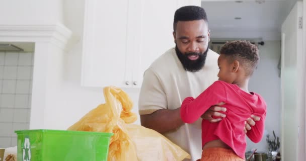 快乐的非洲裔美国父亲和儿子在厨房里整理垃圾 动作缓慢 花费高质量的时间 家庭生活和童年概念 — 图库视频影像
