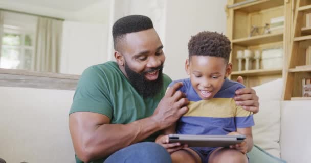 Szczęśliwy Afrykański Ojciec Syn Siedzący Kanapie Używając Tabletu Zwolnionym Tempie — Wideo stockowe