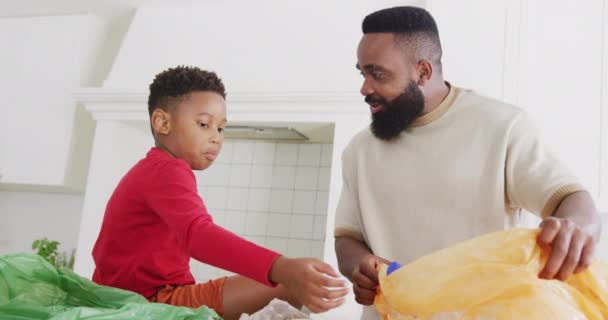 幸せなアフリカ系アメリカ人の父親と息子の台所で廃棄物を分類し ゆっくりと動きます 質の高い時間 家庭生活 子供時代の概念を過ごす — ストック動画