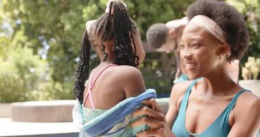 Mutlu Afro-Amerikan annesi yavaş çekimde kızını bilardoda havluyordu. Evde ve yaz konseptinde kaliteli zaman geçirmek.