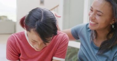 Mutlu çift ırklı kız kardeşlerin portresi bahçede kucaklaşıp gülümsüyor, ağır çekimde. Kaliteli zaman, yaşam tarzı, aile hayatı, aile ve kardeş kavramı.