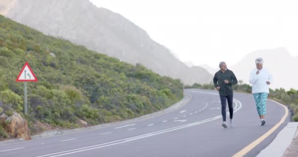 Feliz Casal Birracial Sênior Correndo Estrada Nas Montanhas Caminhadas Estilo — Vídeo de Stock