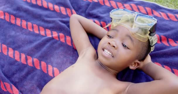 Портрет Счастливого Африканского Мальчика Очках Погружения Лежащих Полотенце Проведение Качественного — стоковое видео
