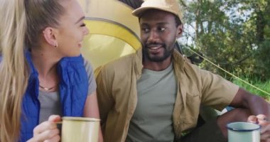 Kamp yapan, çay içen ve parkta konuşan mutlu çift, yavaş çekim. Doğa, yürüyüş ve park konsepti.