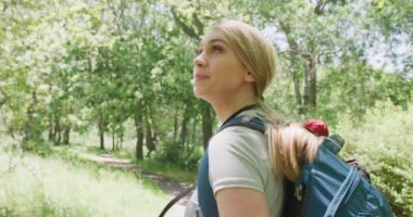 Sırt çantalı mutlu çift parkta fotoğraf çekiyor, ağır çekimde. Doğa, yürüyüş ve park konsepti.