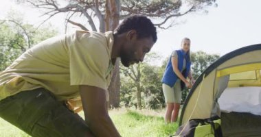 Parkta çadırları olan mutlu çift, ağır çekimde. Doğa, yürüyüş ve park konsepti.