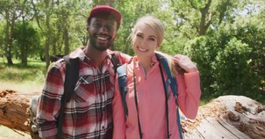 Sırt çantalı mutlu çiftin portresi parkta, ağır çekimde. Doğa, yürüyüş ve park konsepti.