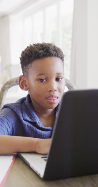 一个快乐的非洲裔美国男孩用笔记本电脑在线授课的垂直视频 动作缓慢 花费高质量的时间 家庭生活和童年概念 — 图库视频影像