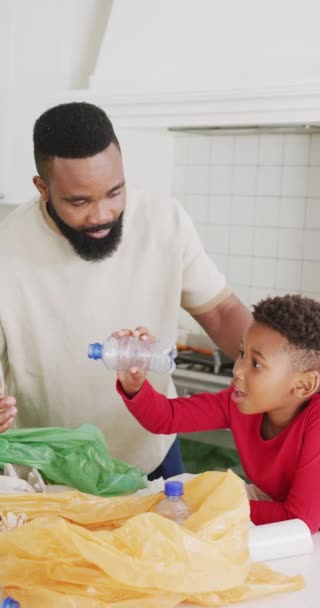 アフリカ系アメリカ人の父親と息子の縦ビデオ台所で廃棄物を分類し スローモーションで 質の高い時間 家庭生活 子供時代の概念を過ごす — ストック動画
