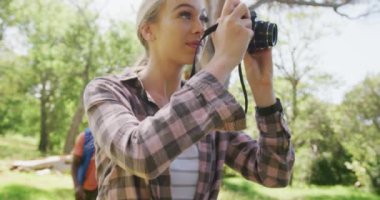 Yürüyen ve parkta fotoğraf çeken mutlu çift, yavaş çekim. Doğa, yürüyüş ve park konsepti.