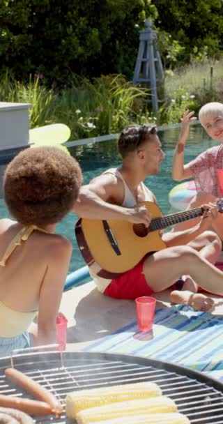 Havuz Partisinde Gitar Çalan Çeşitli Mutlu Arkadaşların Dikey Videosu Kavramında — Stok video