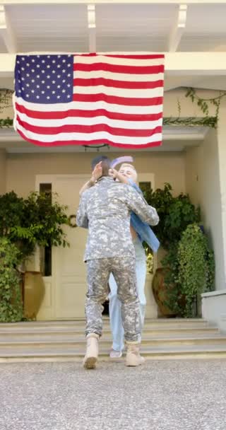 Pionowe Wideo Szczęśliwego Zróżnicowanego Żołnierza Obejmującego Żonę Amerykańską Flagą Patriotyzm — Wideo stockowe