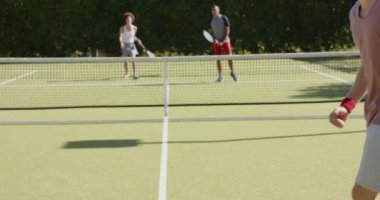 Tenis oynayan ve tenis kortunda kutlama yapan farklı arkadaş grupları mutlu olsun. Ev kavramında arkadaşlık ve kaliteli zaman geçirme.