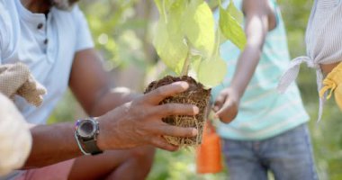 Büyükbabamla birlikte bahçede ağır çekimde çalışan mutlu Afro-Amerikan kardeşler. Ev kavramında kaliteli zaman geçirmek.