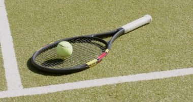 Tenis raketi ve tenis topu güneşli bir günde tenis kortunda yatıyor. Spor ve aktif yaşam tarzı kavramı.