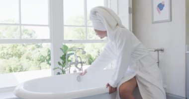 Banyoda banyo yapan mutlu Asyalı kadın, ağır çekimde. Kaliteli zaman, yaşam tarzı ve ev hayatı kavramı harcamak.