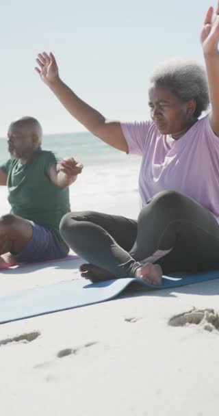 非洲裔美国老人夫妇在海滩做瑜伽的垂直录像 动作缓慢 花费高质量的时间 生活方式 退休和度假概念 — 图库视频影像