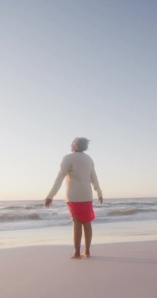 影片中快乐的老年非洲裔美国妇女在海滩张开双臂 动作缓慢 花费高质量的时间 生活方式 退休和度假概念 — 图库视频影像